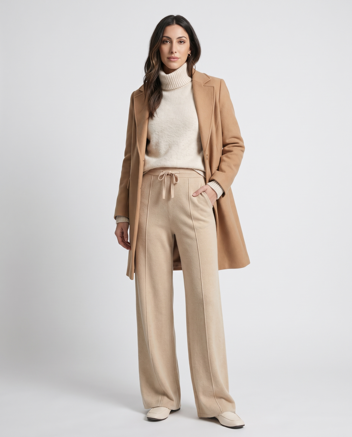 Model in camel coat and cream turtleneck wearing camel wide-leg pants
