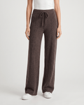 Merino wool wide-leg pants in dark brown, front view with drawstring and sneakers