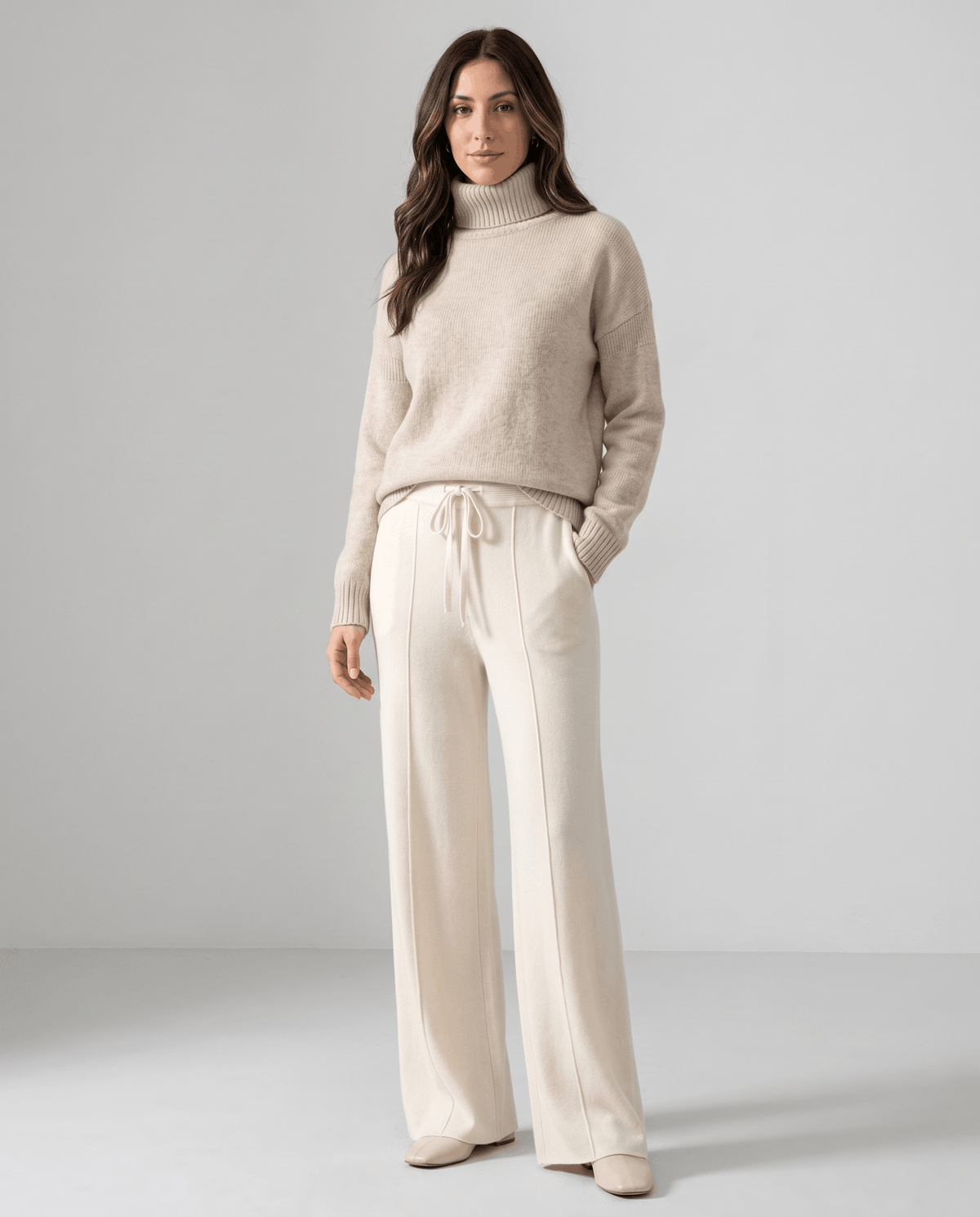 Model in oatmeal turtleneck and ivory wide-leg knit pants