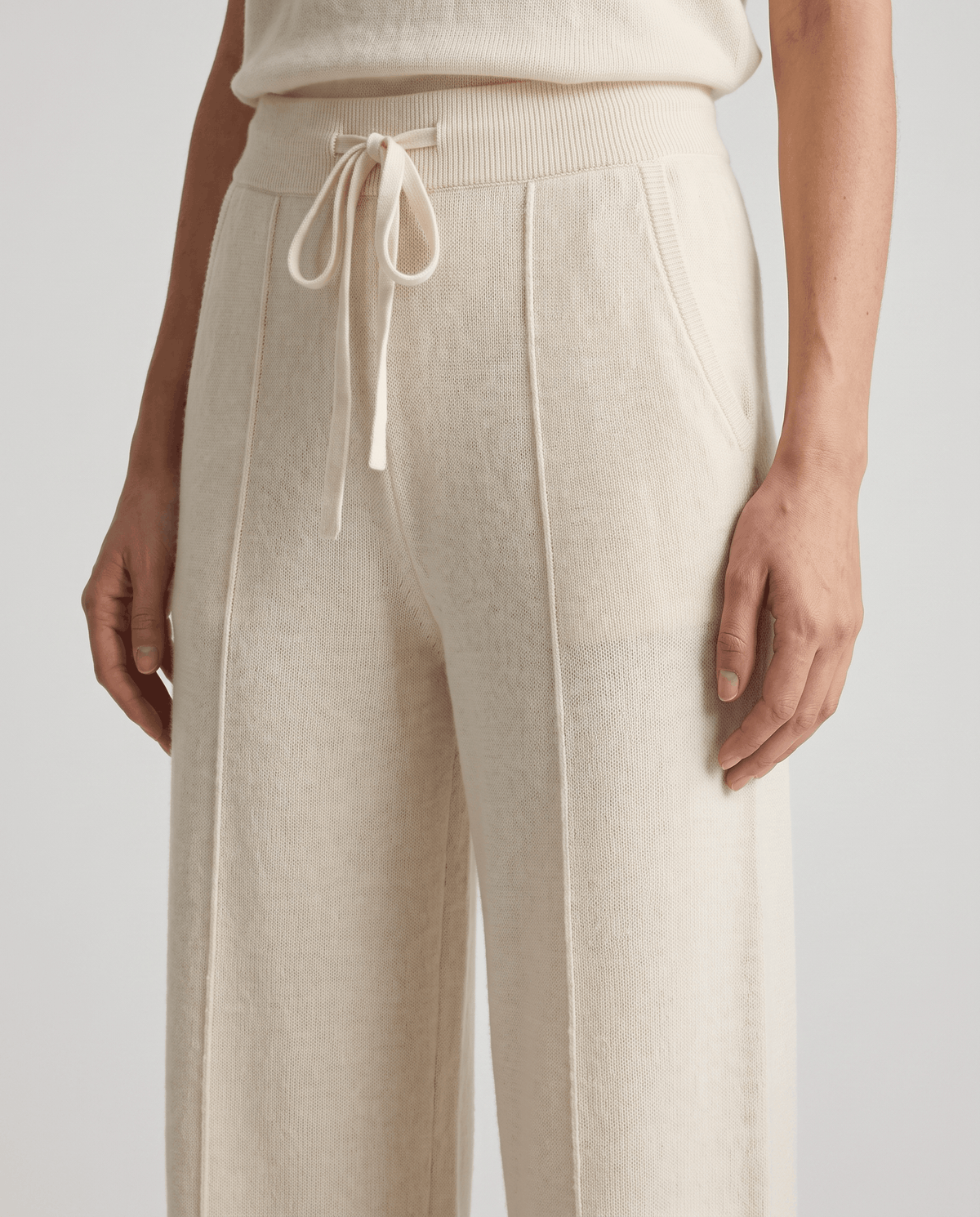 Close-up of ivory drawstring waist with pintuck seams and pocket