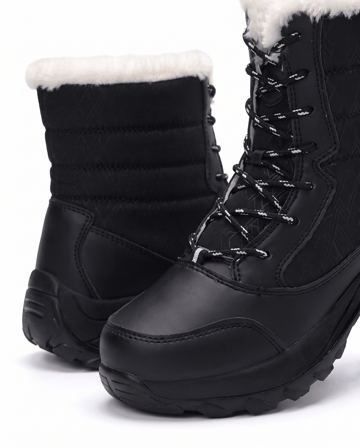 Close view of black lace-up boot showing laces, smooth toe panel and quilted upper