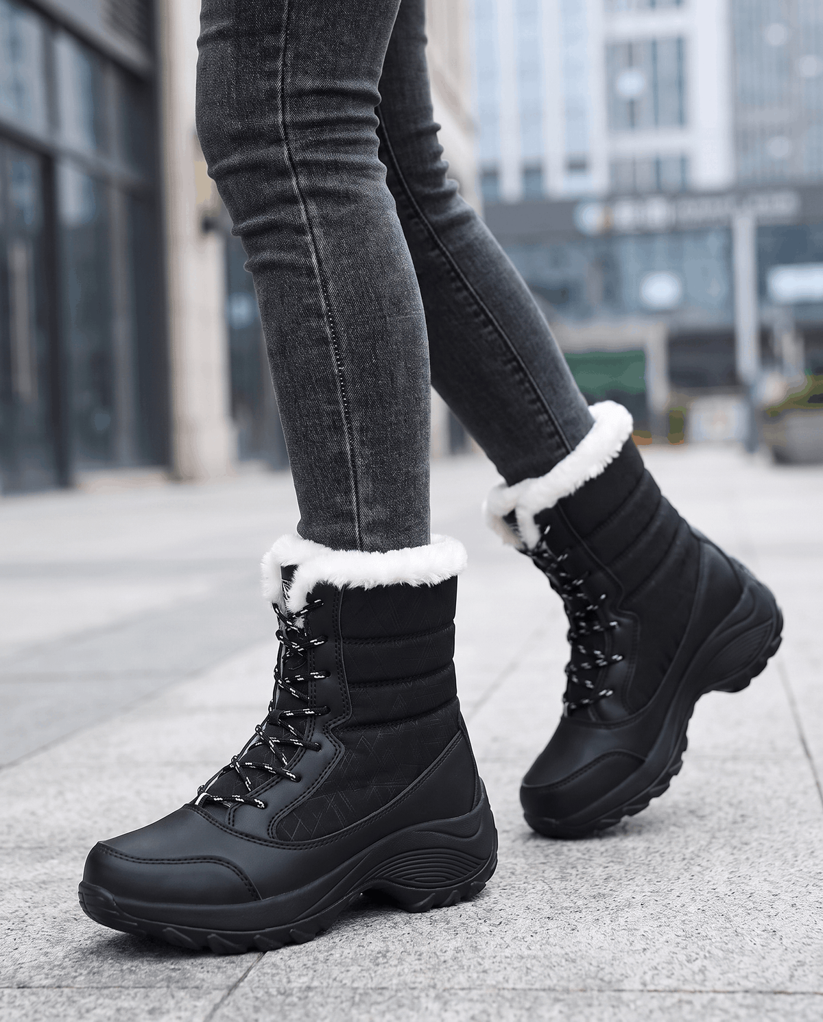 Black lace-up boots with chunky soles and plush collars worn with dark jeans on sidewalk