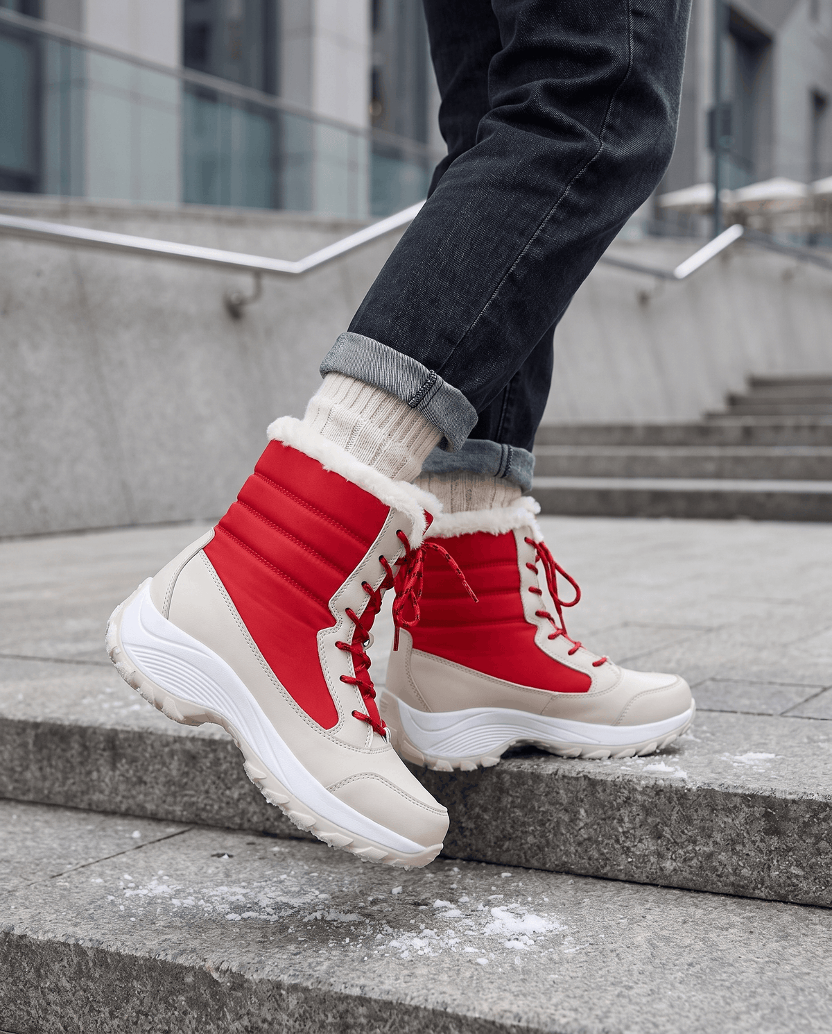Red lace-up boots worn with cuffed jeans and white socks while standing on stone steps