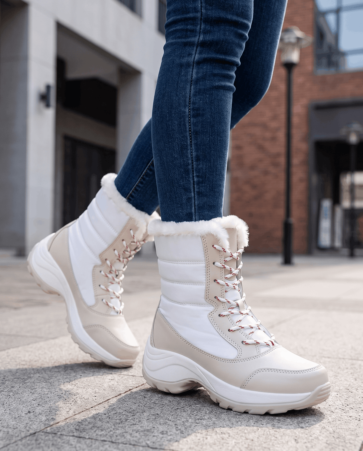 White lace-up boots with chunky platform soles worn with jeans while walking outdoors