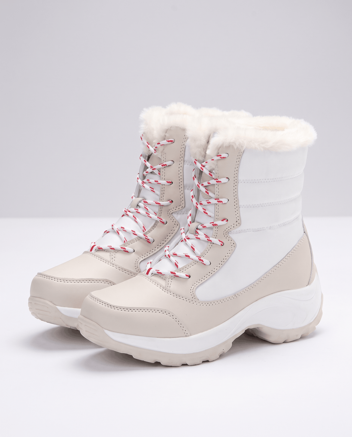 White and cream lace-up boots with pink laces, quilted upper and plush collar on pale backdrop