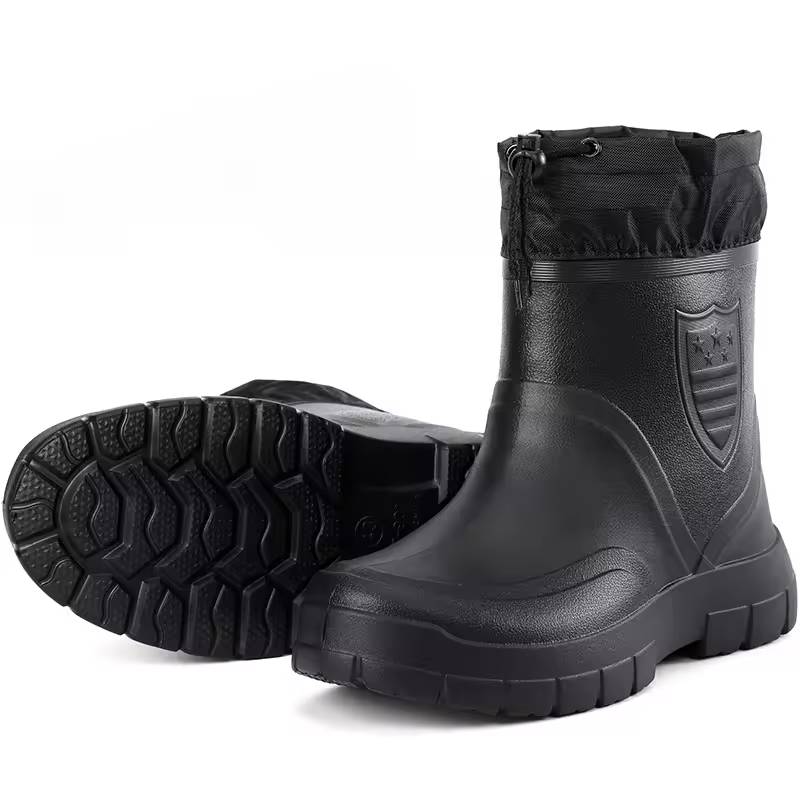 Two black boots with one turned to show the deep treaded sole pattern