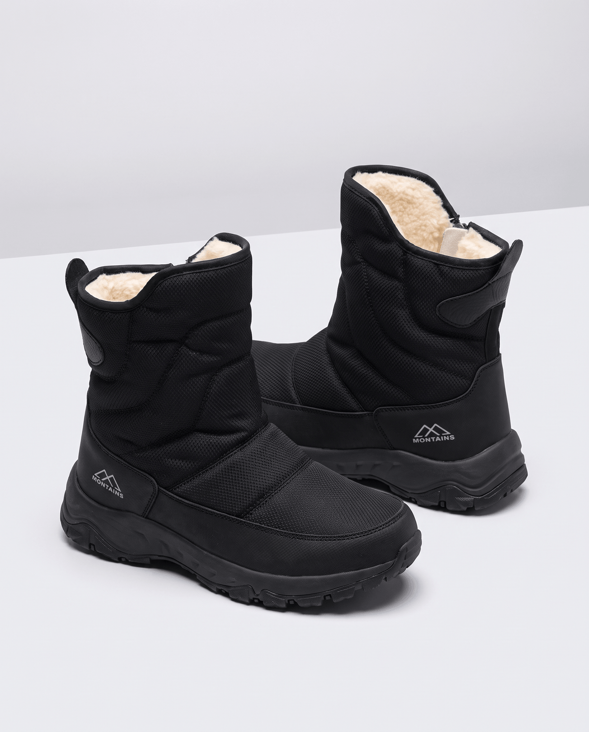 Pair of black boots angled to show the cream fleece lining and quilted upper