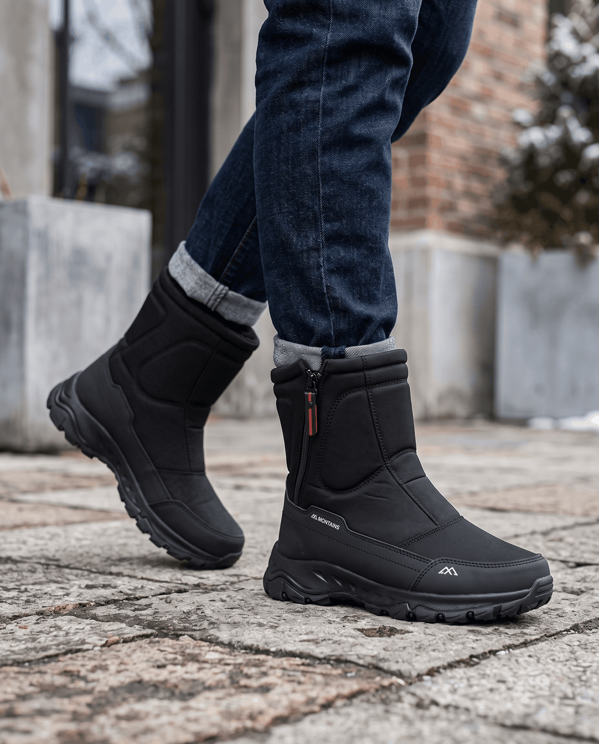 Black zip-up boots with chunky soles worn with dark jeans on a snowy sidewalk