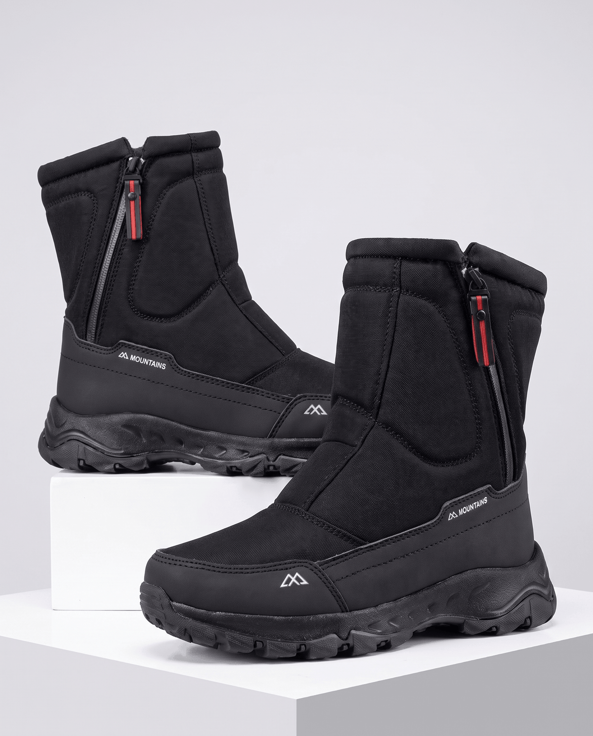 Pair of black zip-up boots angled to show front zippers and thick lug soles