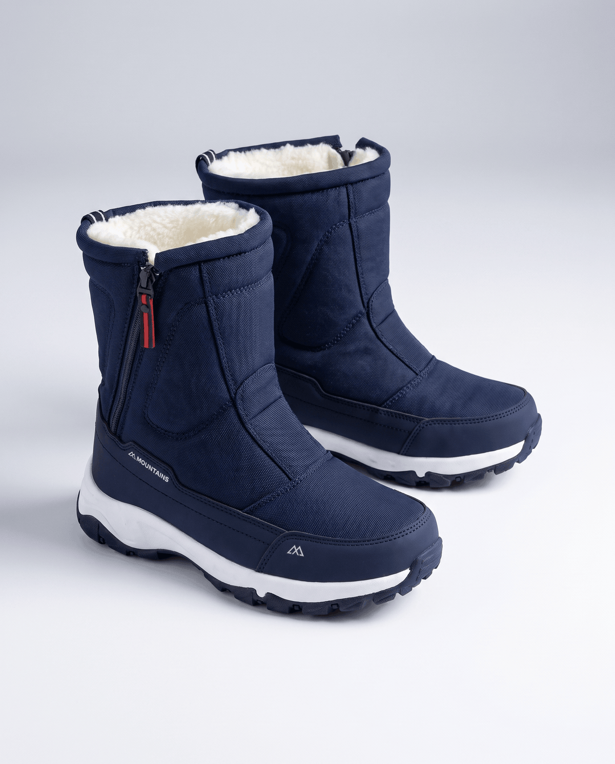 Pair of navy blue zip-up boots angled to show fleece collars and white sole edge