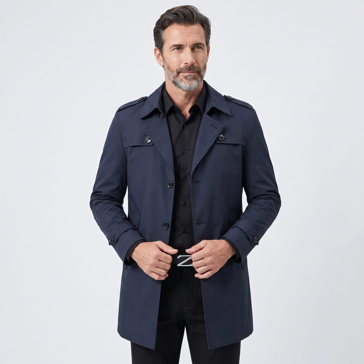 Model in navy blue trench coat with epaulets and cuff straps, front view