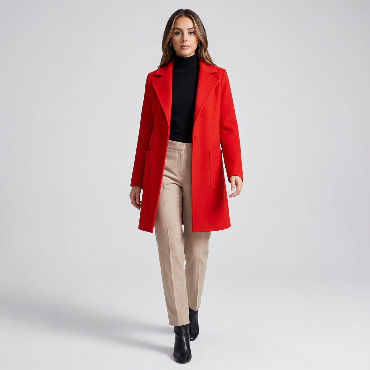 Model walking in cherry red coat with beige trousers and black ankle boots