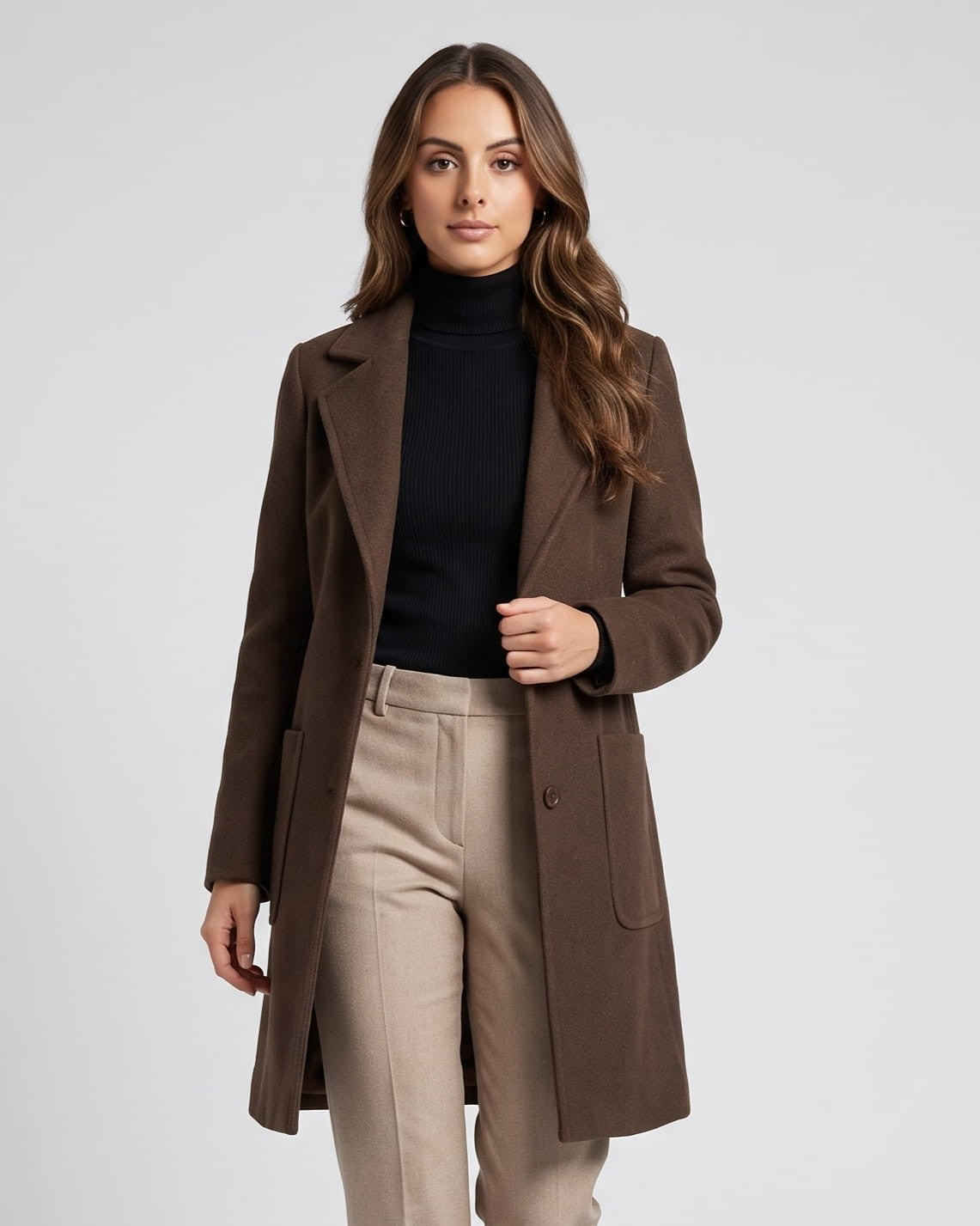 Coffee brown coat worn over black turtleneck and beige trousers, front view