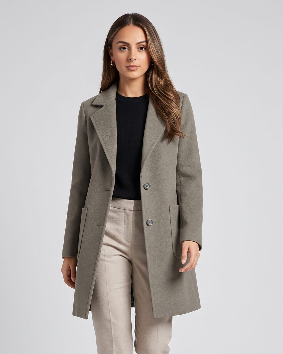 Olive green coat with notched lapels and patch pockets over beige trousers