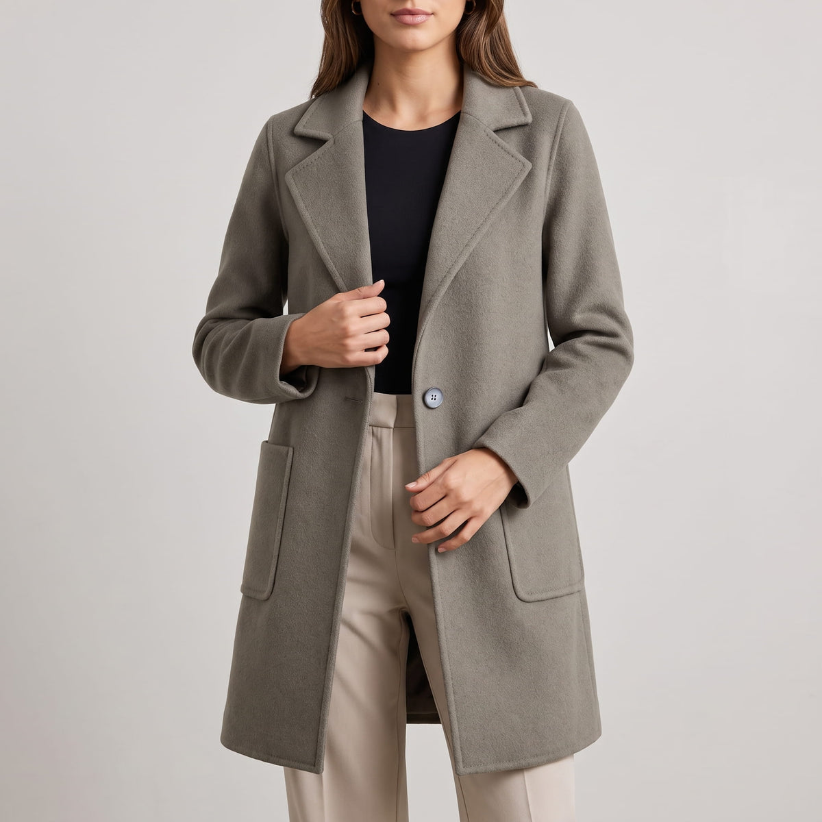 Close-up of olive green coat front worn over a black top