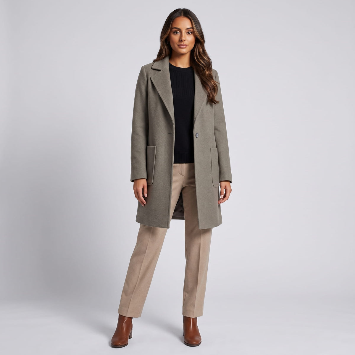 Full-length view of olive green coat with beige trousers and brown boots