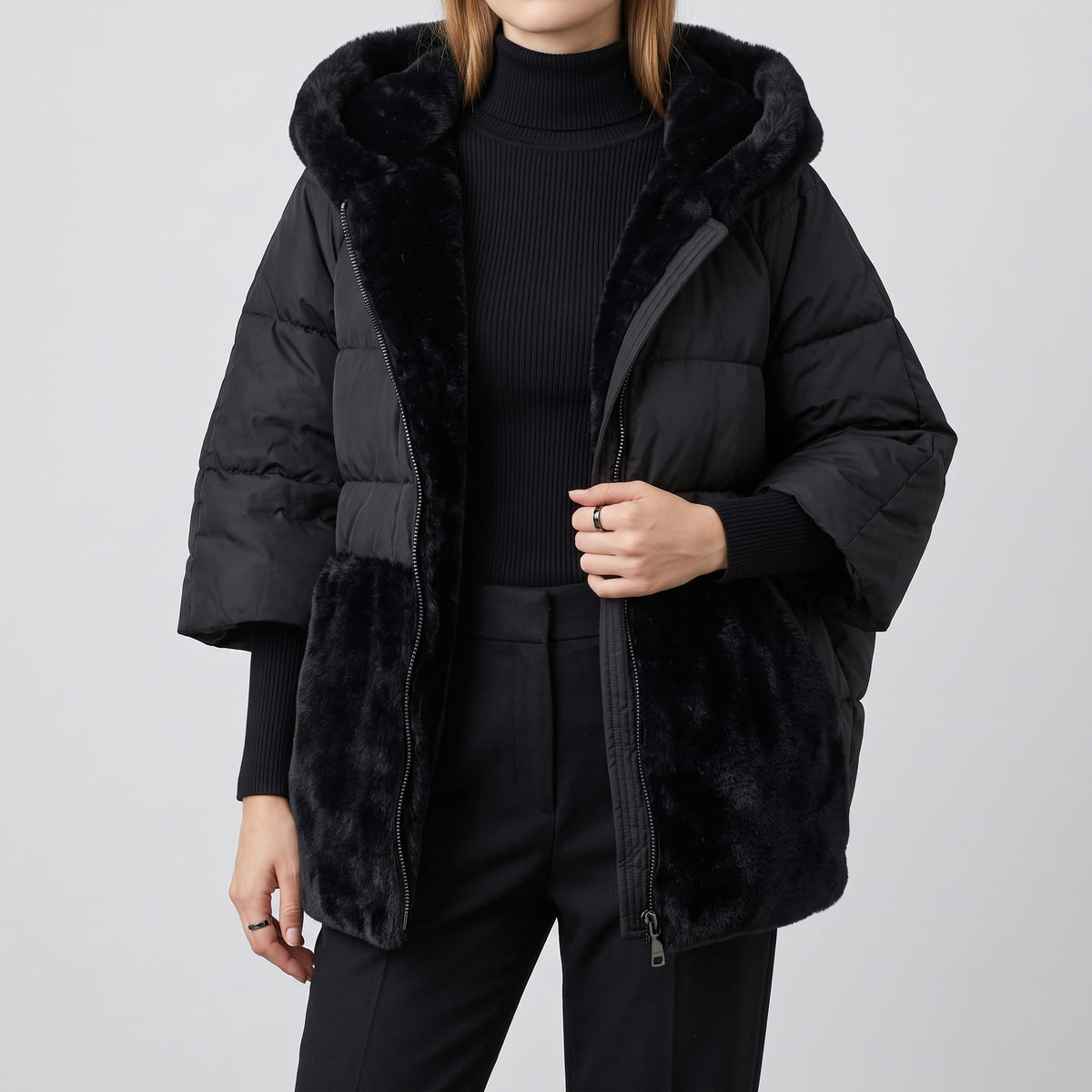 Black parka worn open over a black turtleneck, showing the plush hem