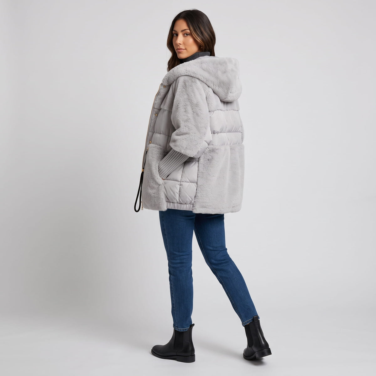 Back three-quarter view of gray parka with hood, worn with blue jeans