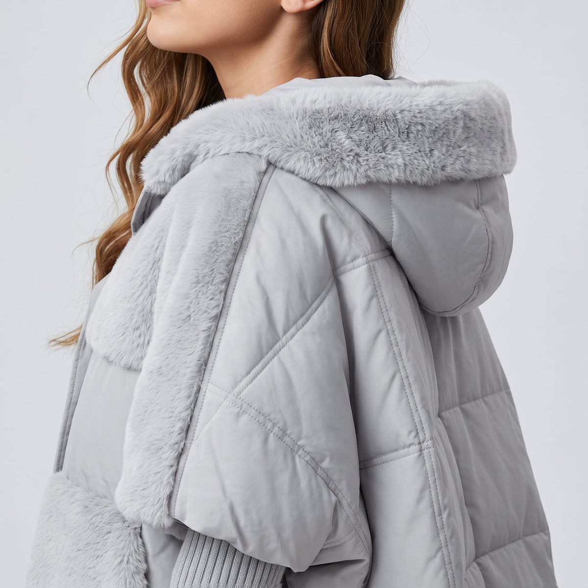 Side close-up of the gray plush hood and quilted shoulder panel