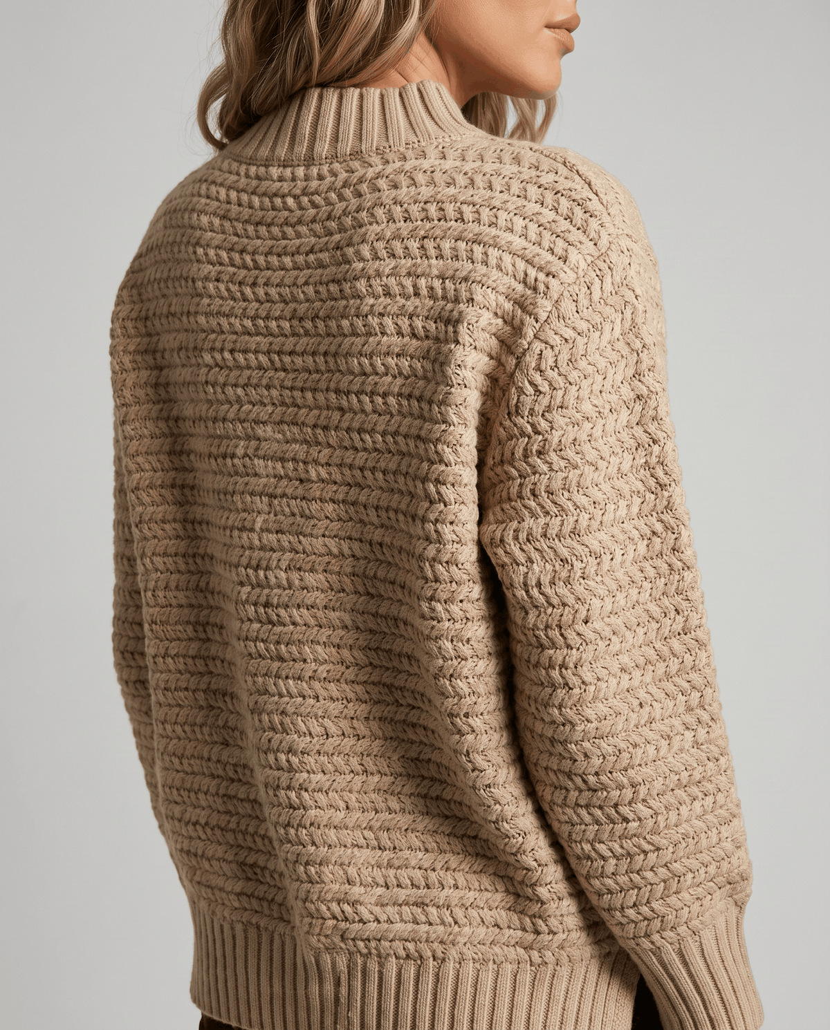 Back view of beige chunky knit sweater showing textured stitch and ribbed hem