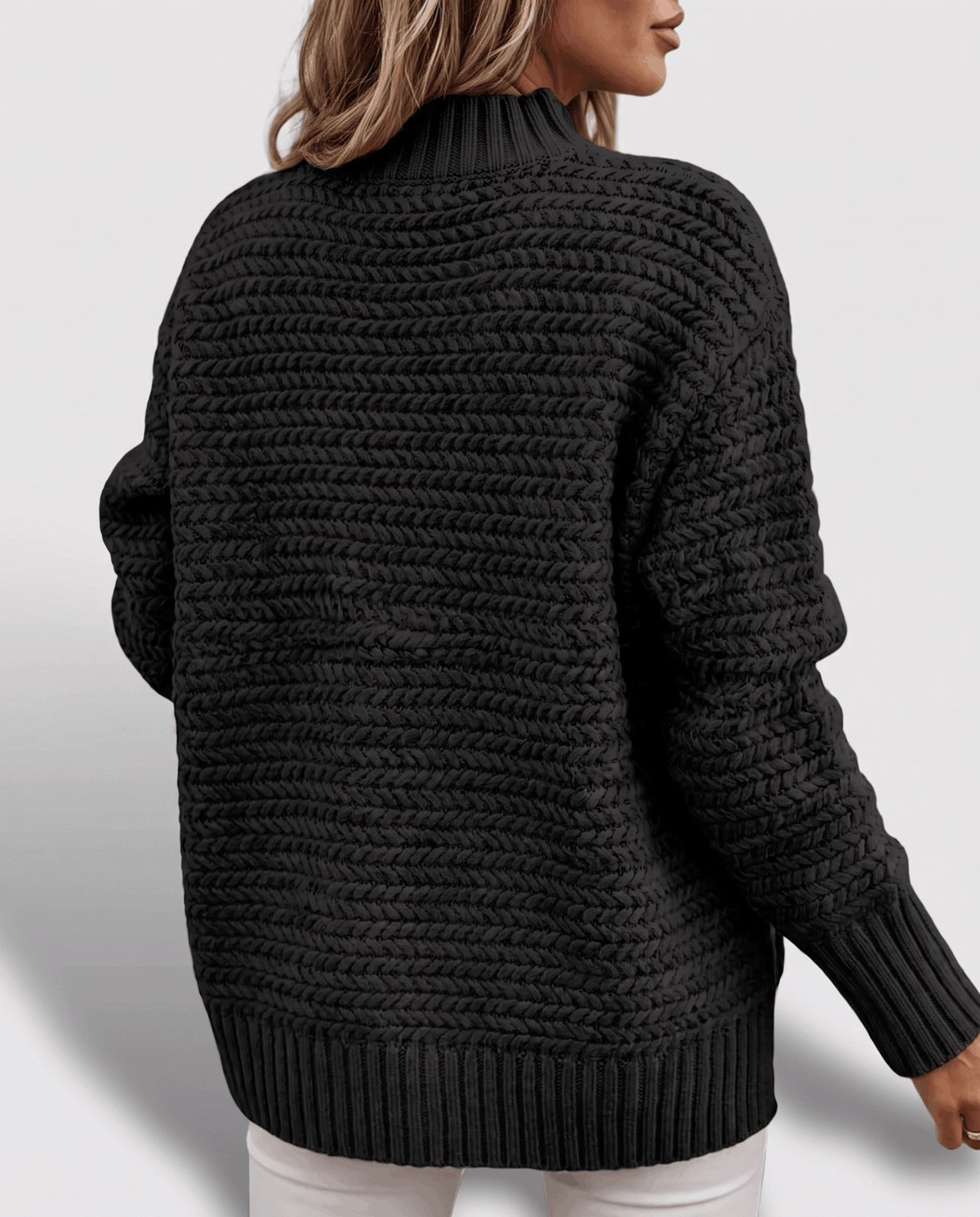 Back view of black oversized sweater showing dropped shoulders and ribbed hem