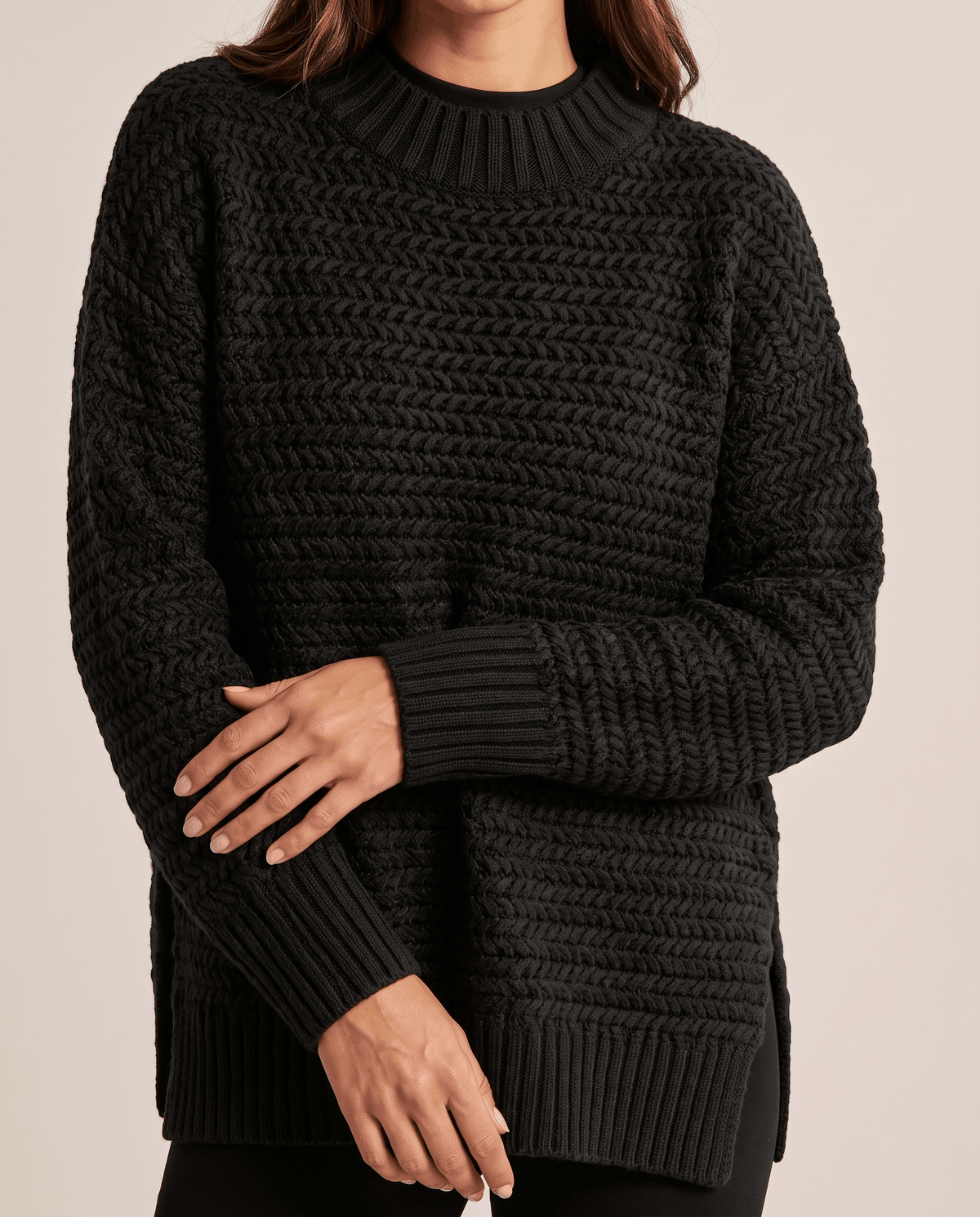 Cropped front view of black textured knit sweater with ribbed cuffs