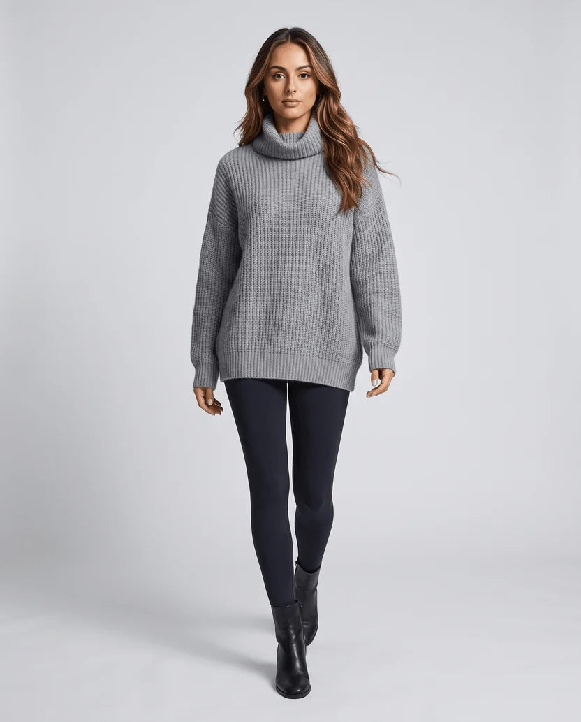 Full-length front view of model in gray turtleneck sweater with black pants