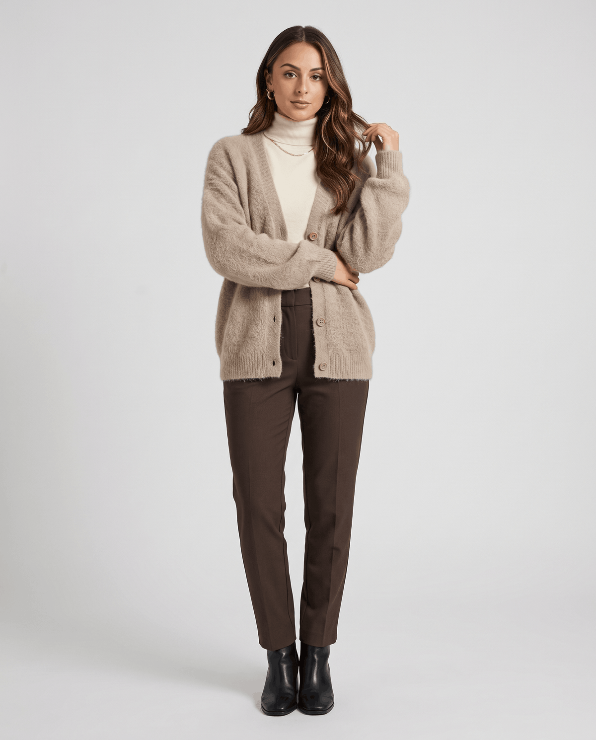 Full-length beige cardigan outfit with brown trousers and black ankle boots