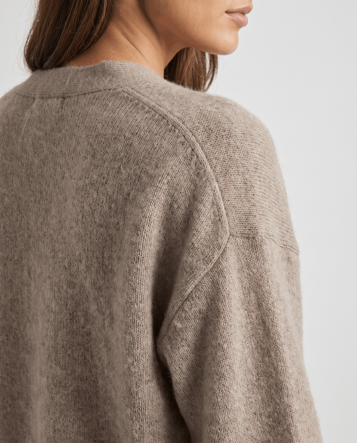 Detail of the beige knit across the shoulder seam showing its fuzzy texture