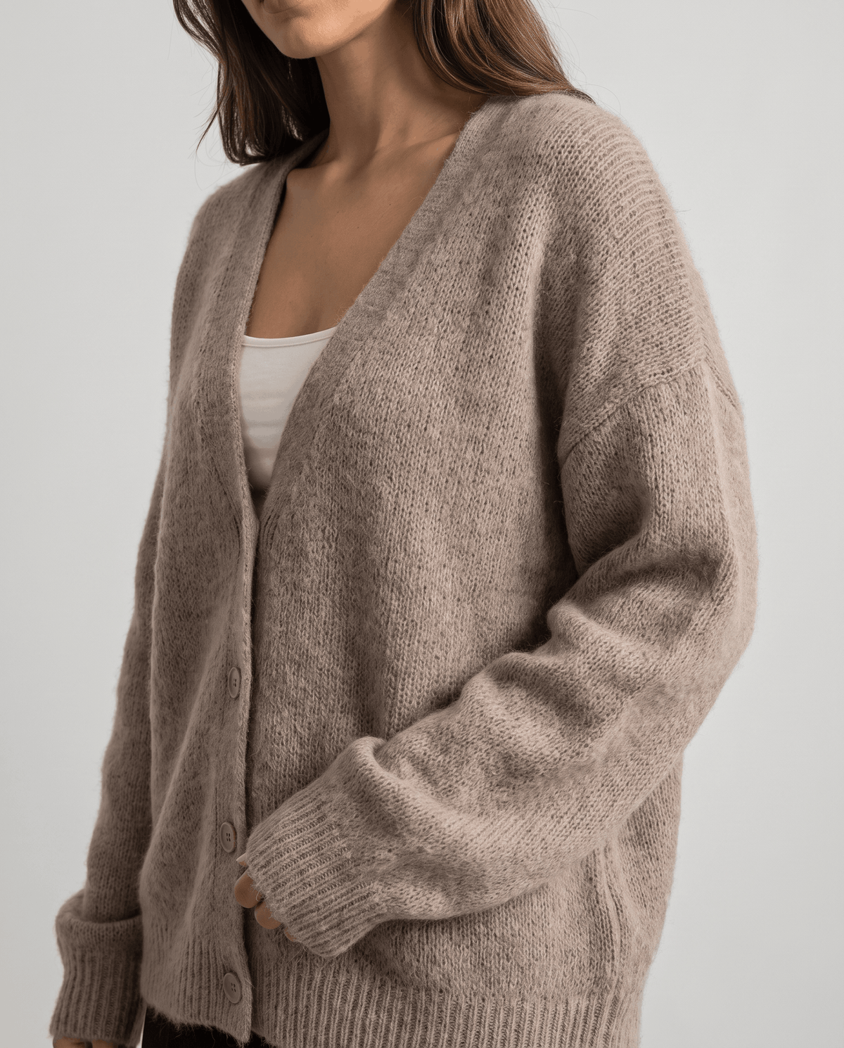 Side view of the beige cardigan highlighting the dropped shoulder and long sleeve