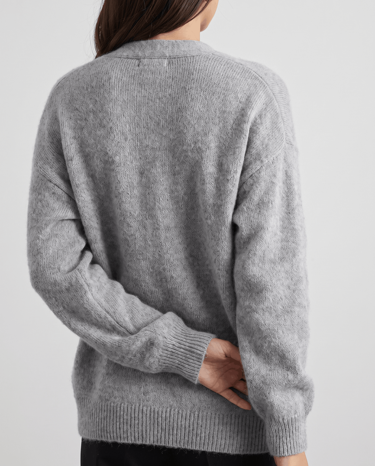 Back view of the gray cardigan showing its relaxed drop-shoulder fit and ribbed hem