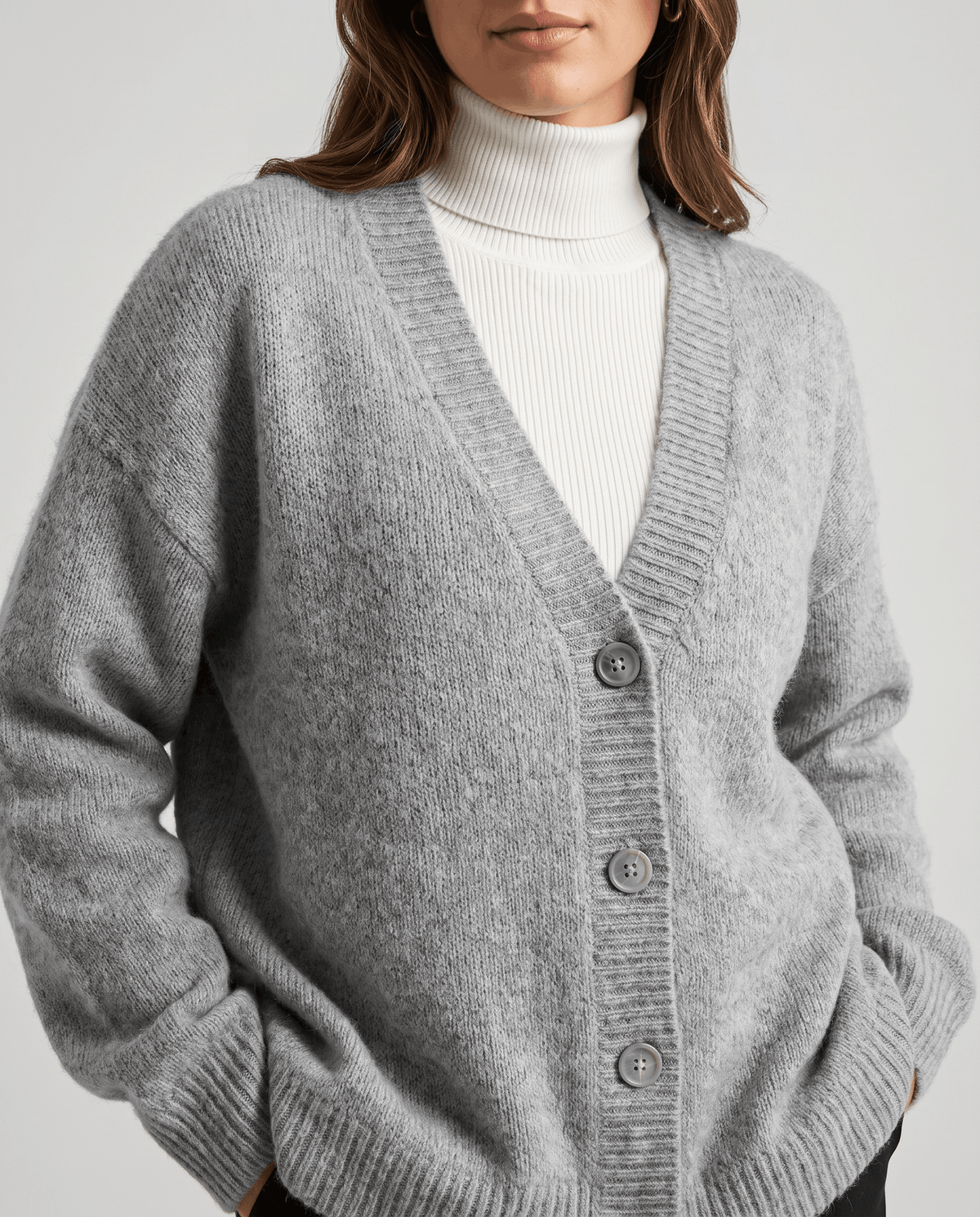 Close-up of the gray fuzzy knit with button front worn over a white turtleneck