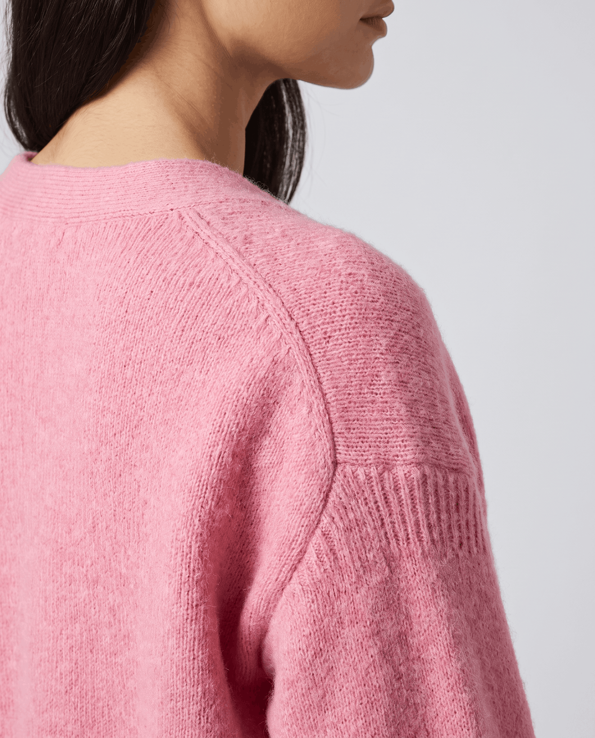 Detail of the pink fuzzy knit along the shoulder seam and upper sleeve