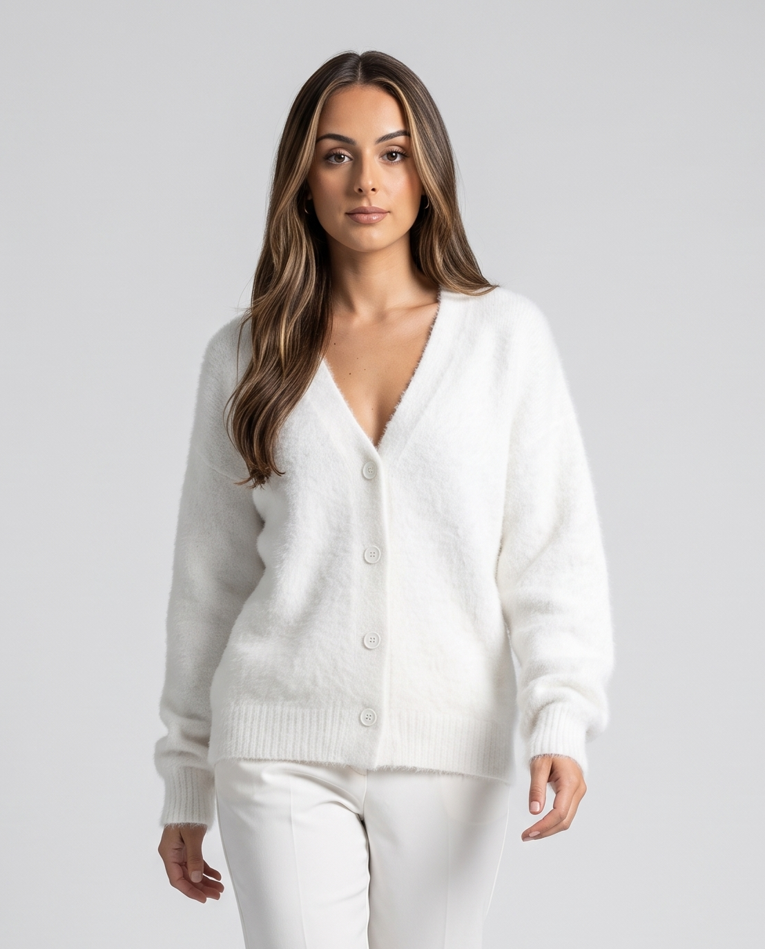 White cardigan buttoned over matching white pants in a studio front view