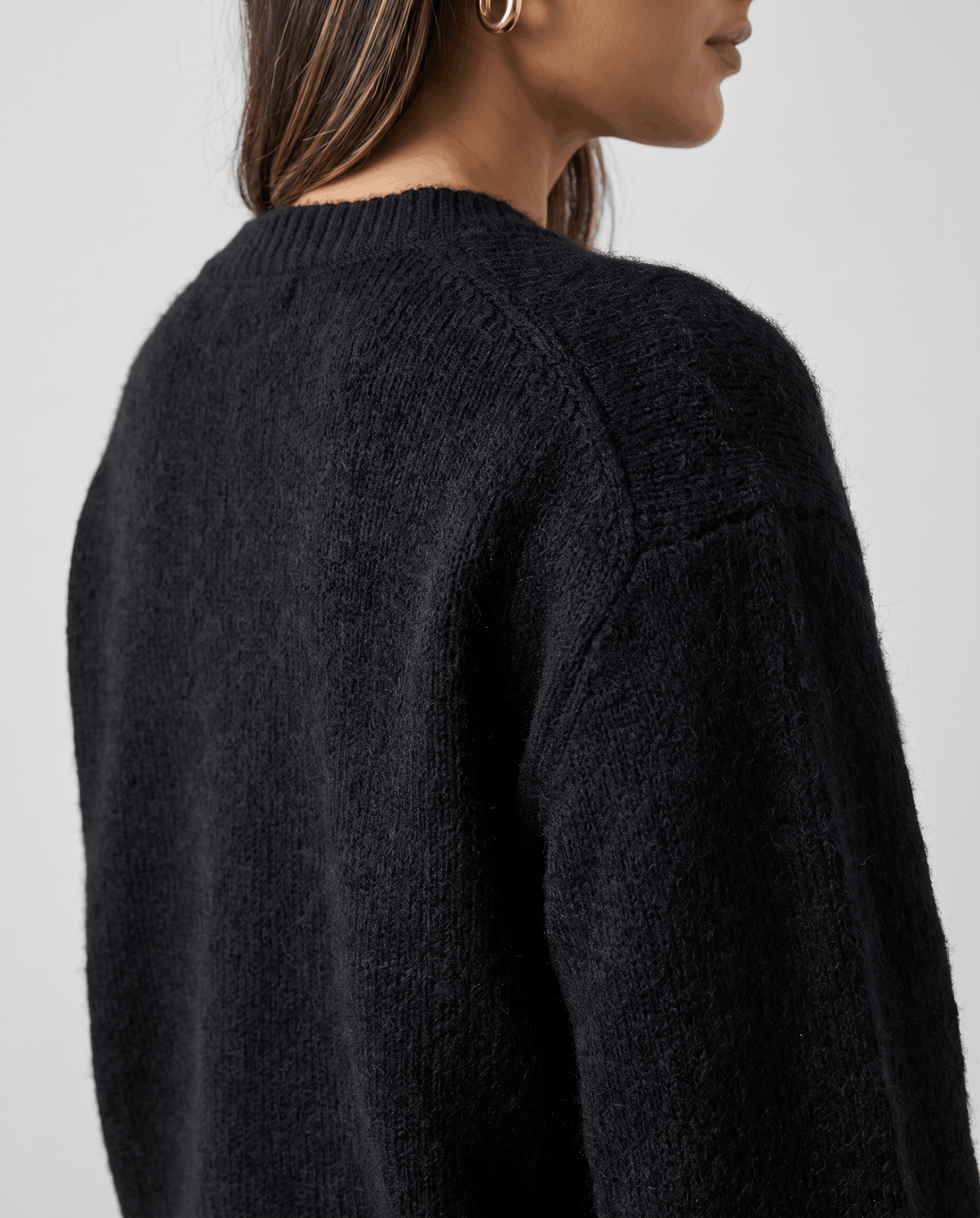 Back shoulder detail of the black fuzzy knit and dropped seam