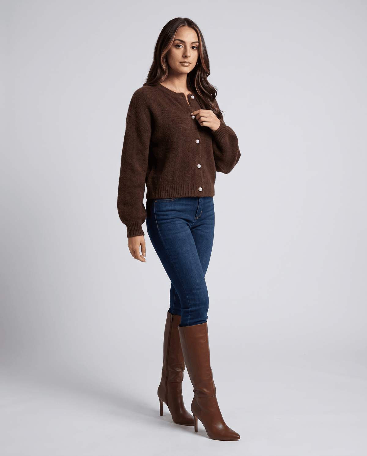 Full-length view of the brown cardigan with jeans and brown heeled knee-high boots