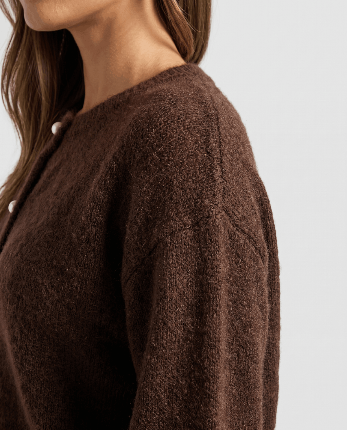 Shoulder detail of the brown cardigan showing the soft fuzzy knit and dropped seam