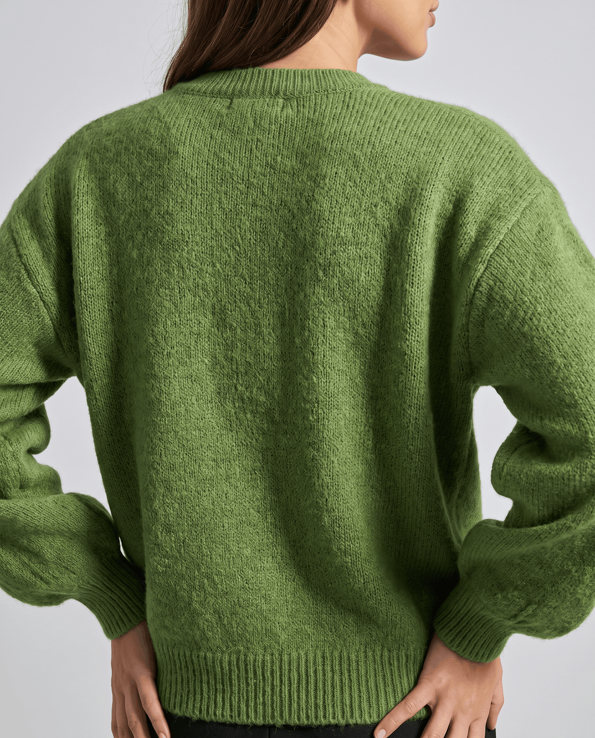Back view of the green cardigan with balloon sleeves and a ribbed hem