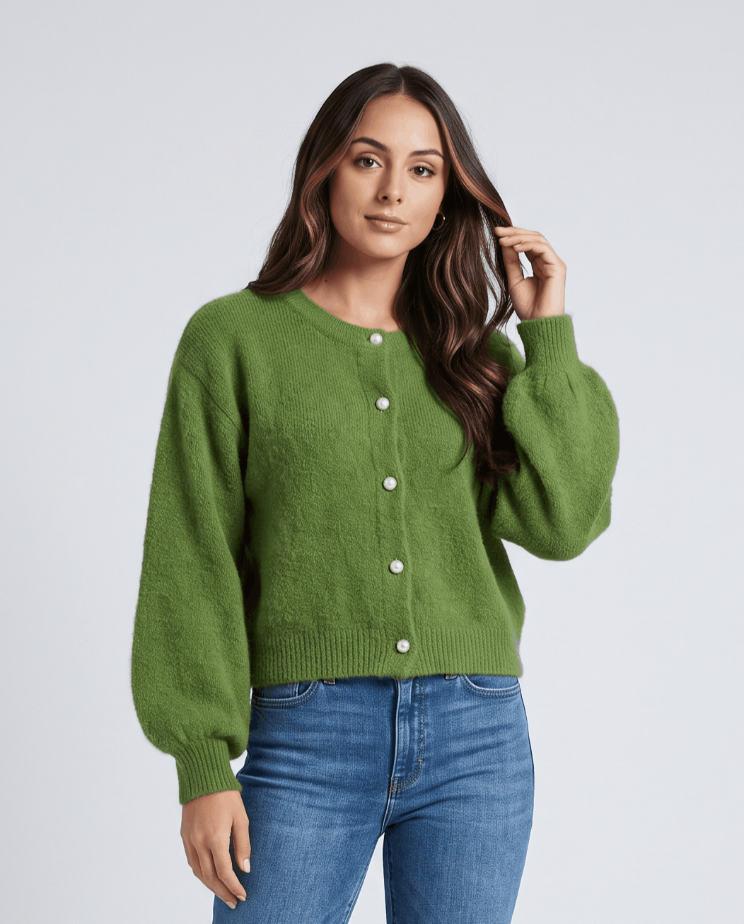 Green cardigan with balloon sleeves tucked into light blue jeans