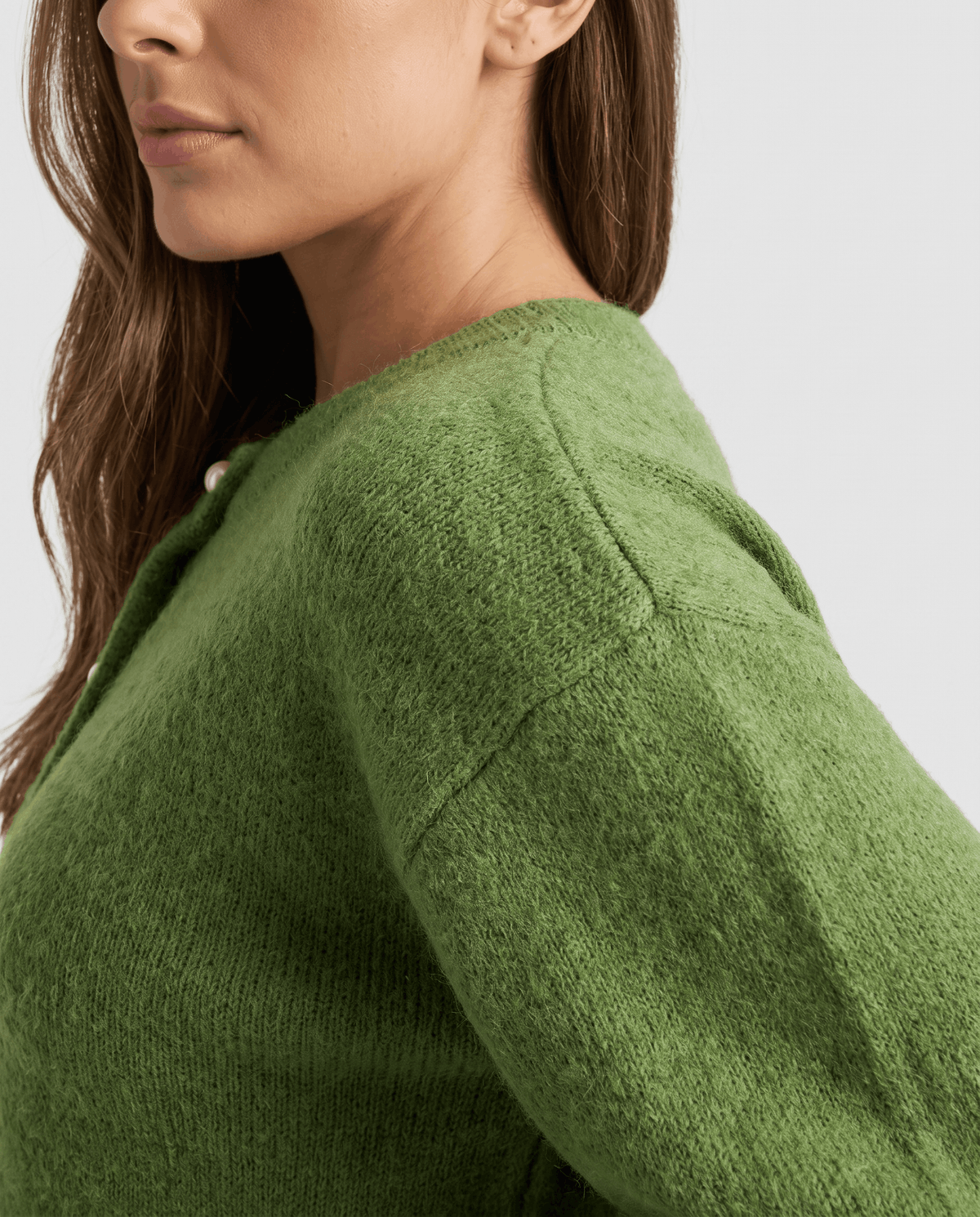 Shoulder detail of the green cardigan showing its brushed knit and dropped seam