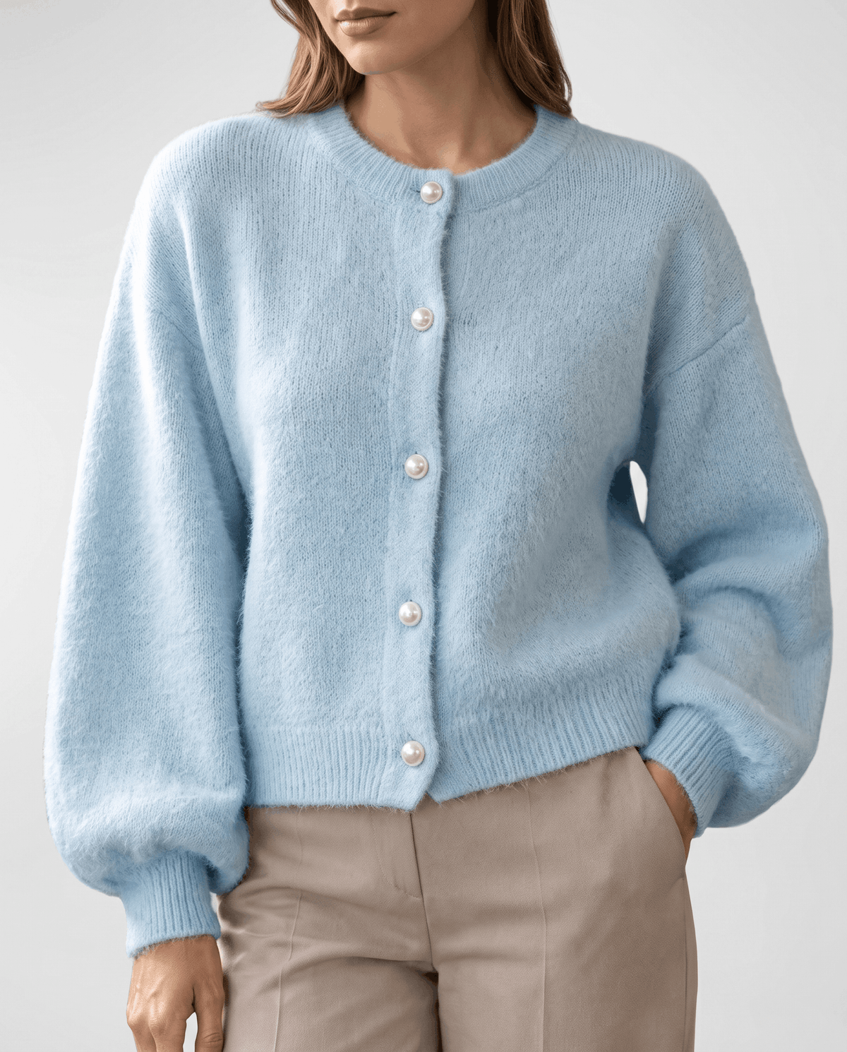 Front view of the light blue knit cardigan fully buttoned with pearl-effect buttons