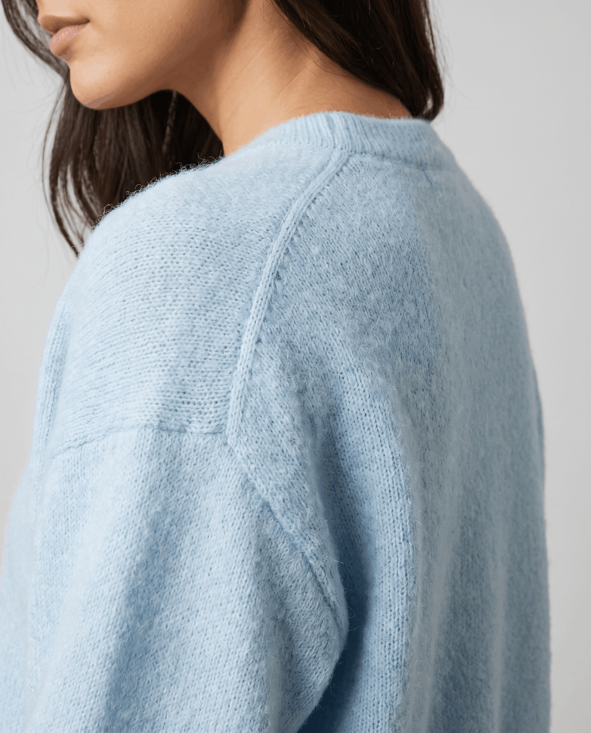 Shoulder detail of the light blue cardigan showing the dropped seam and fuzzy knit