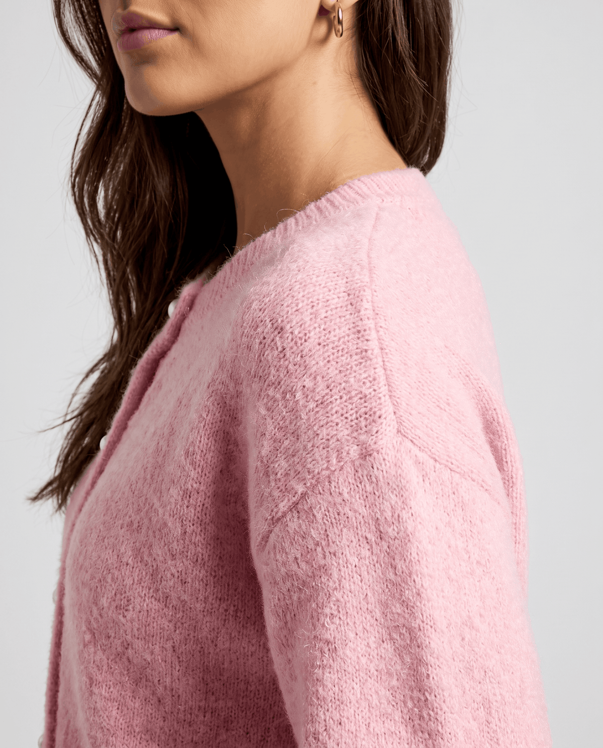 Side shoulder detail of the pink cardigan showing the soft brushed knit texture