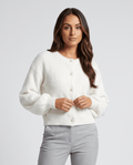 Women's pearl button cardigan sweater in white with gray trousers