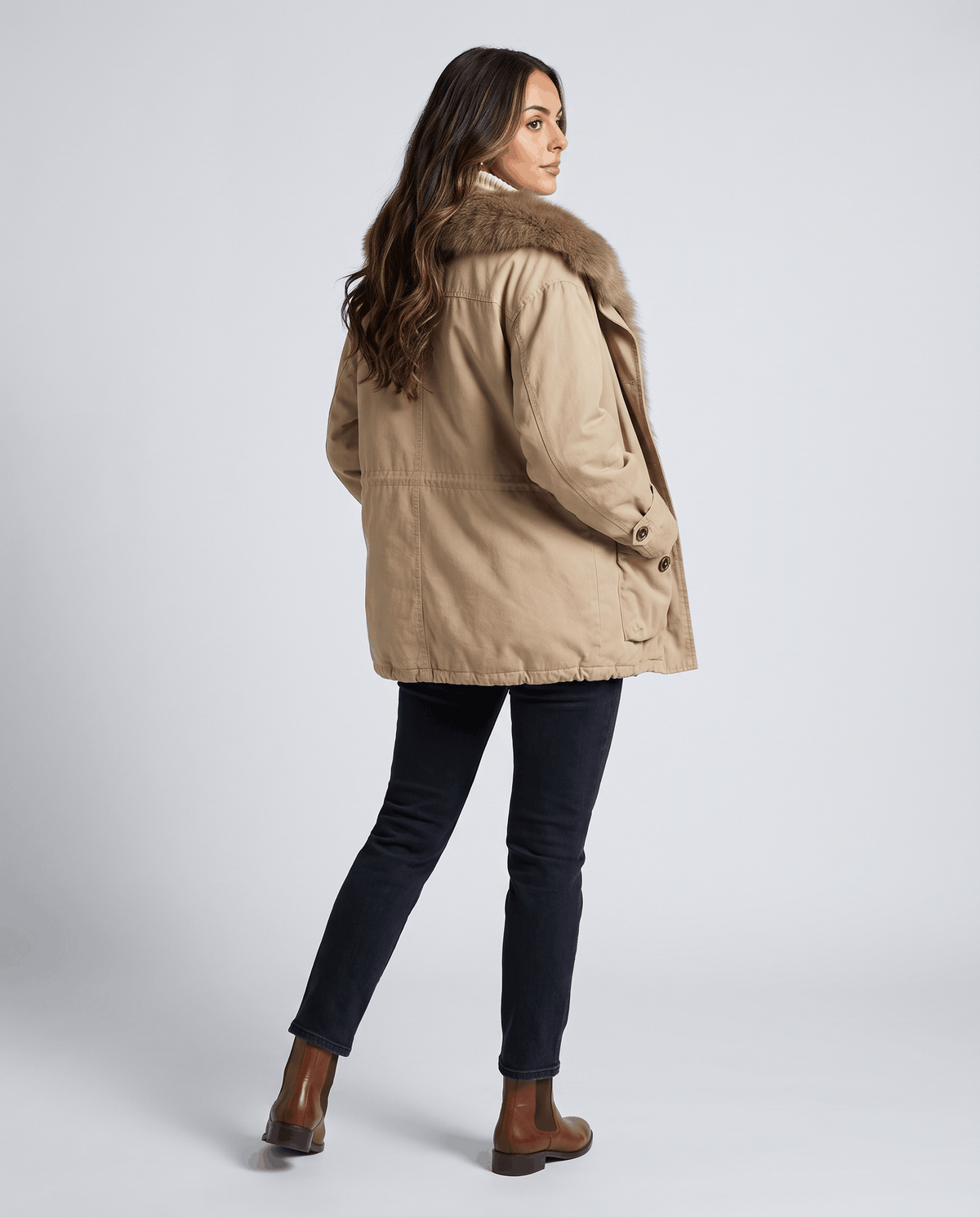 Back view of khaki parka with dark jeans and brown ankle boots