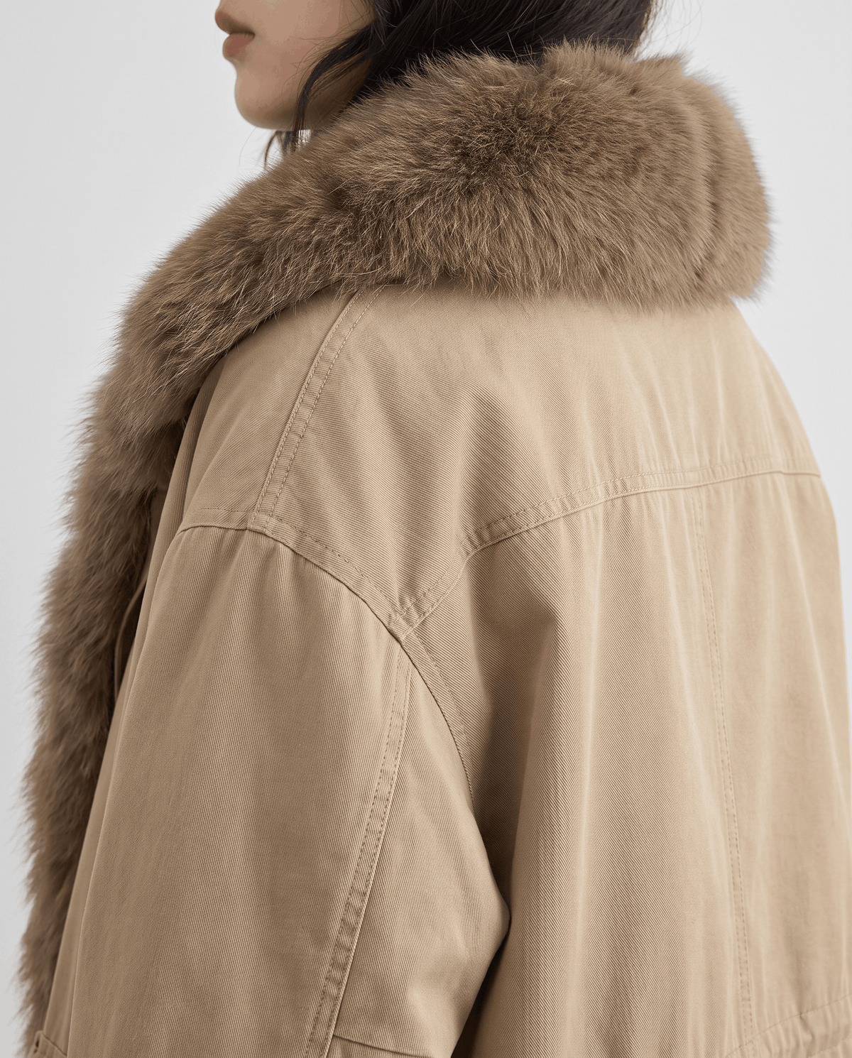 Rear shoulder detail of the wide plush collar on a khaki parka
