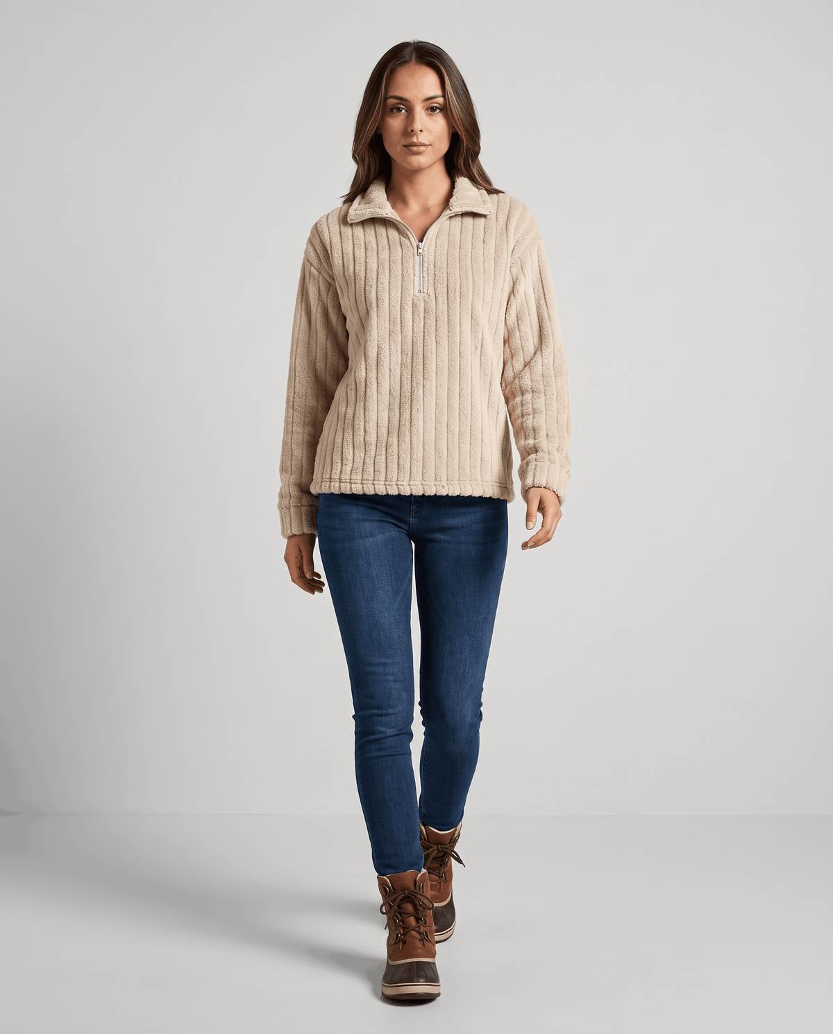 Full-length view of beige ribbed pullover with jeans and brown ankle boots