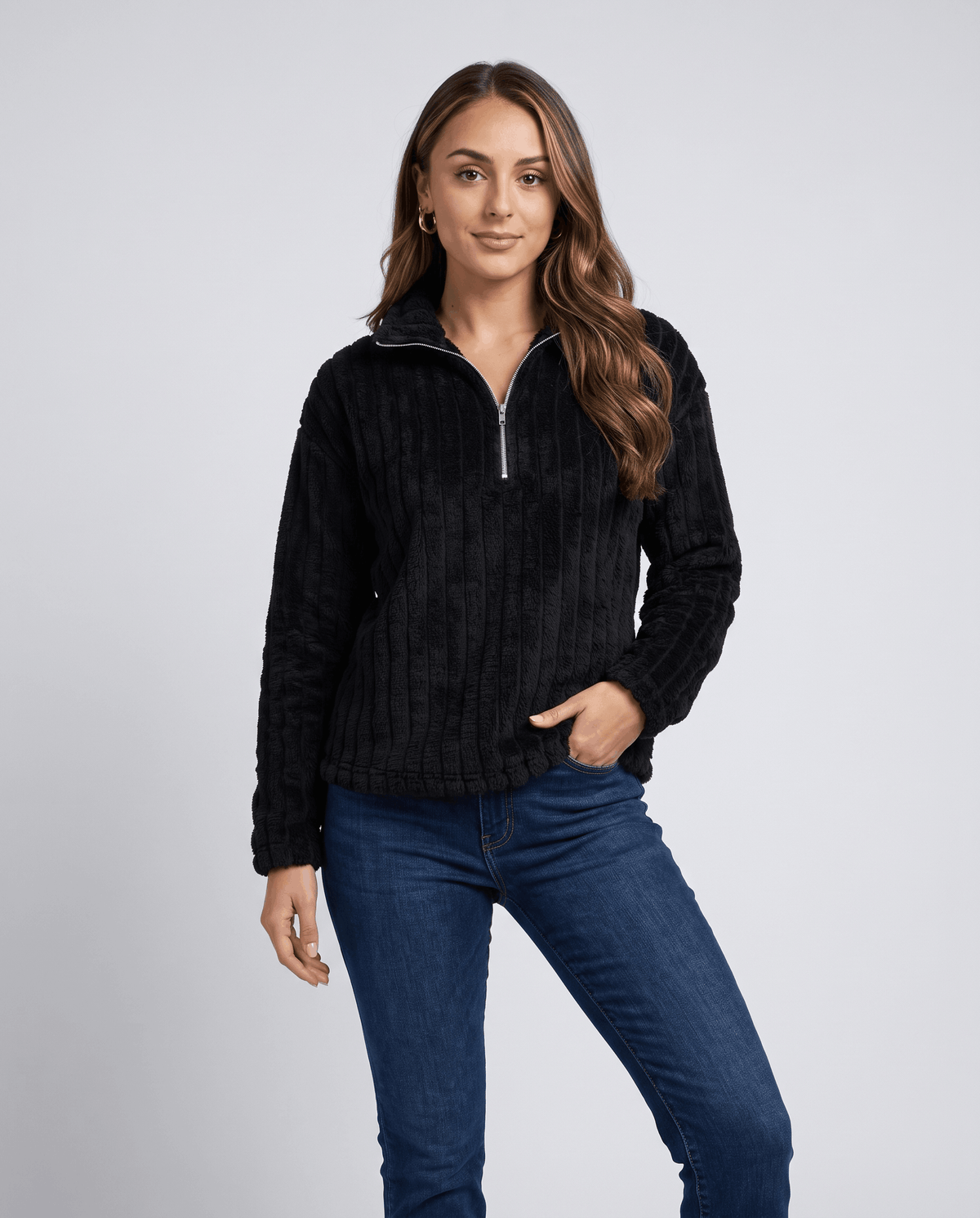 Front view of black plush pullover styled with medium wash jeans