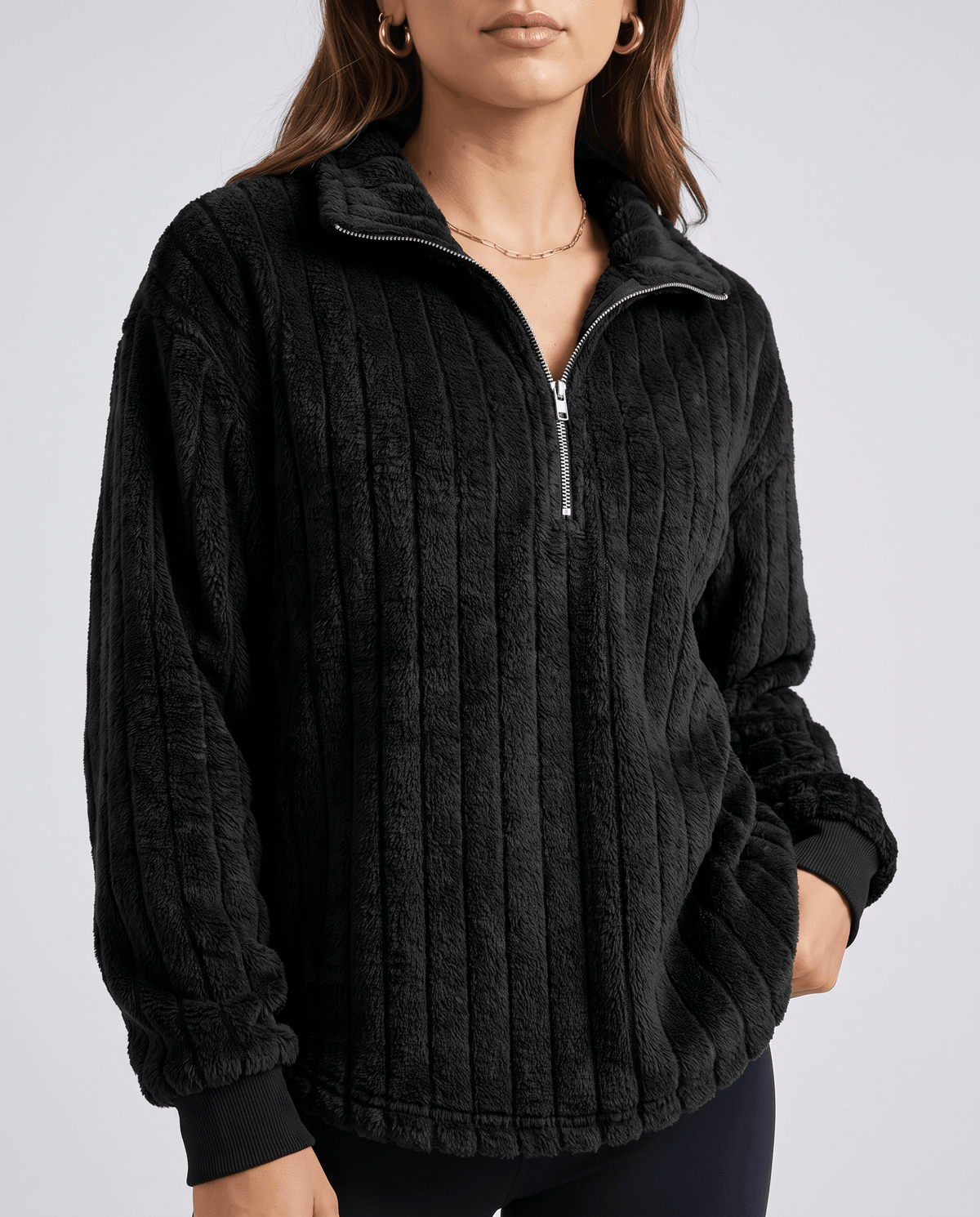 Cropped front view of black plush ribbed pullover with silver zip and dark pants