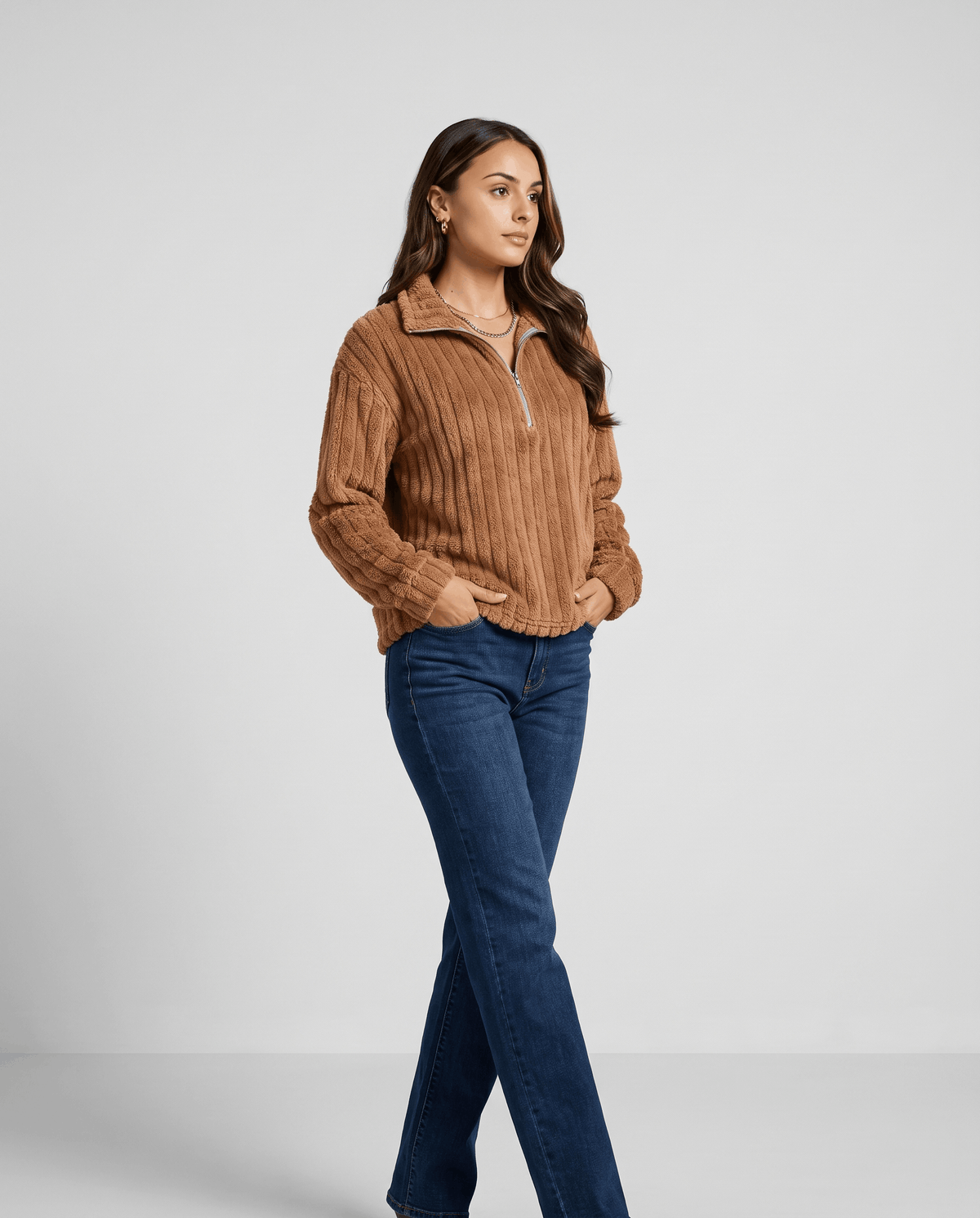 Full-length view of camel brown pullover with dark jeans and ankle boots